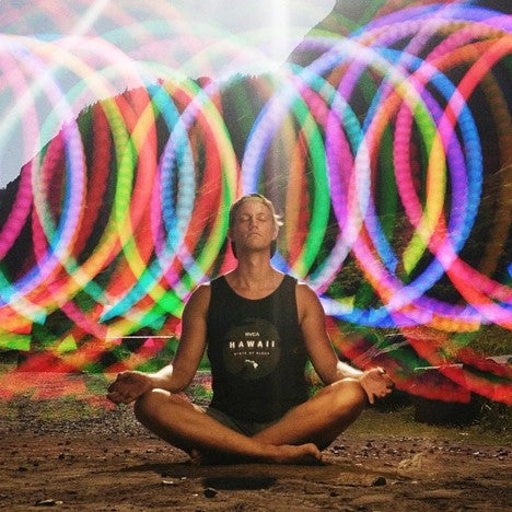 Jacob Raagaard sitting cross legged in front of swirling neon lights