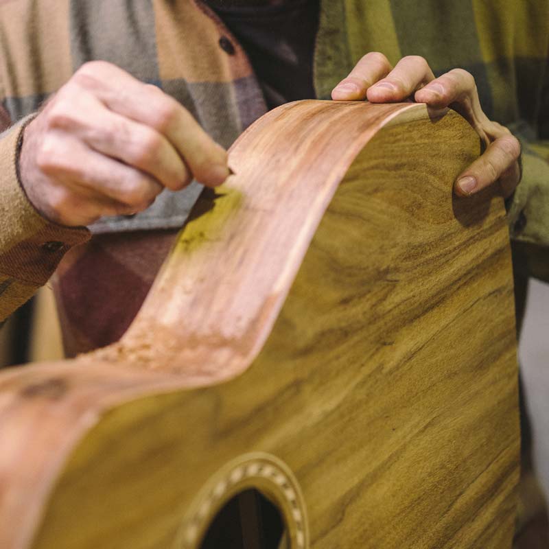 Richard Wilson scraping the side of a Koa Weissenborn.